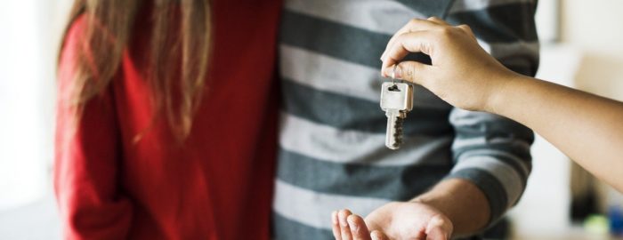 Young couple holding the keys to their new home.