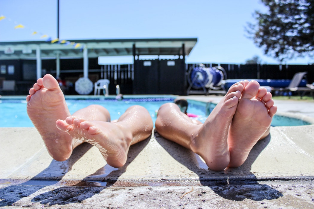 Feet sticking out of a pool.