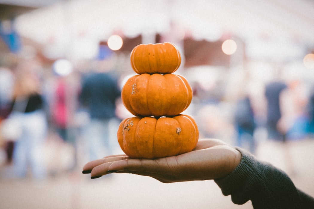 A person holding small gourds in their hand.