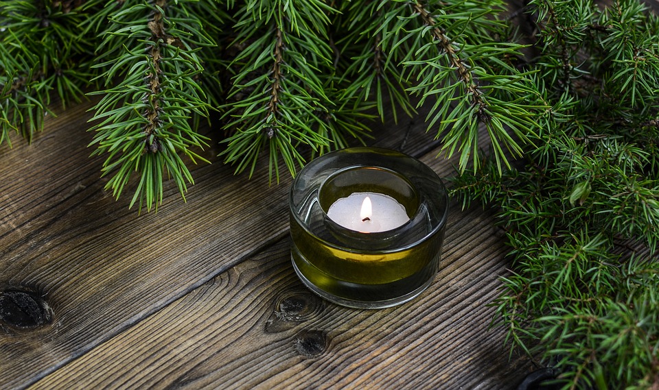 Neutral holiday decor of a tea candle and greenery.